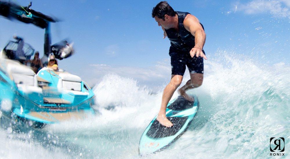 man wakesurfing behind a boat on the water